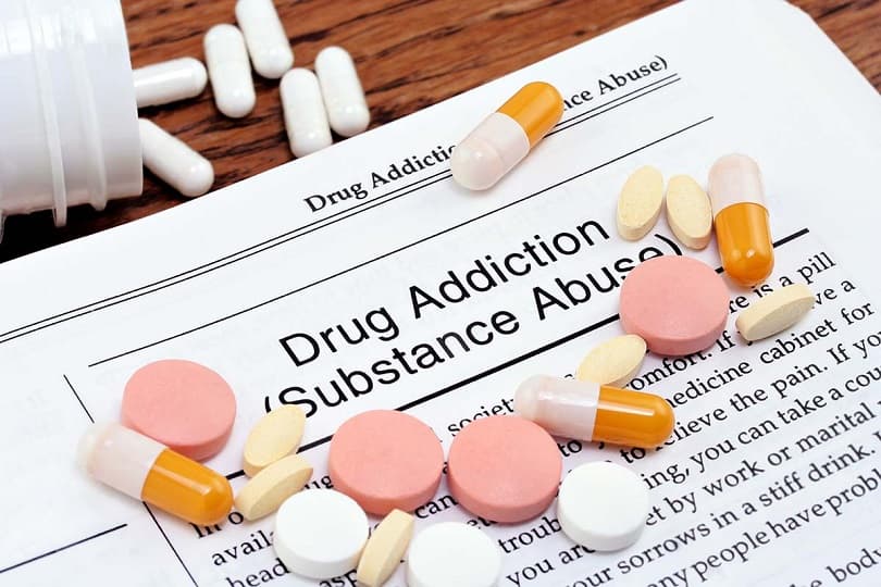 Medication and pills beside a clipboard labelled Drug Addiction Substance Abuse