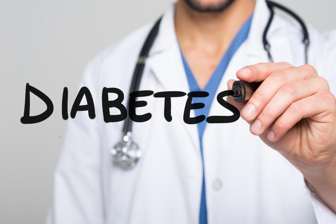 A doctor writing the word Diabetes on a glass screen