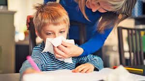 A mother wiping a child's nose